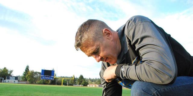 Former Bremerton High School assistant football coach Joe Kennedy at the center of the field on the 50-yard line at Bremerton Memorial Stadium.