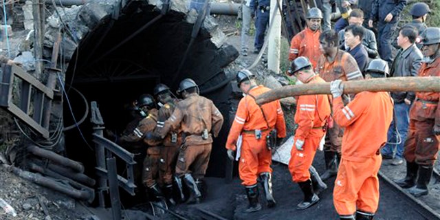 Rescue workers descend into the coal mine where a gas leak in the morning killed 20 miners and trapped another 23 in Shizong county in southwest China's Yunnan province Thursday Nov. 10, 2011.