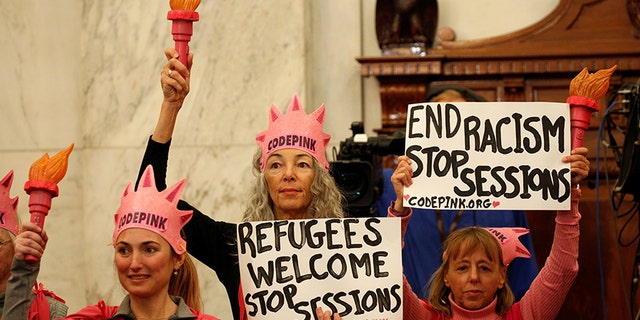 Protesters hold signs at the Senate Judiciary Committee confirmation hearing for U.S. Sen. Jeff Sessions (R-AL) to become U.S. attorney general on Capitol Hill in Washington, U.S. January 10, 2017.