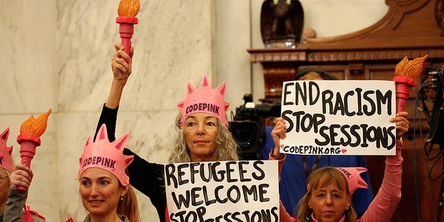 Protesters hold signs at the Senate Judiciary Committee confirmation hearing for U.S. Sen. Jeff Sessions (R-AL) to become U.S. attorney general on Capitol Hill in Washington, U.S. January 10, 2017.