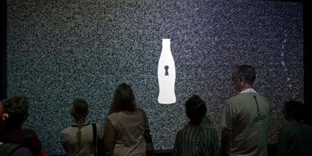 Aug. 9, 2013: A tour group waits for an interactive experience to begin before entering the vault chamber containing the “secret recipe” for Coca-Cola at the World of Coca-Cola museum, in Atlanta.