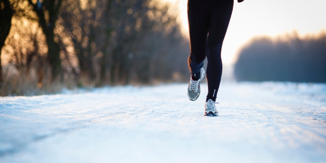 Winter running - Young woman running outdoors on a cold winter day