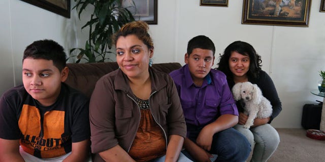 July 31, 2014: Adriana Gaytan, who came to Colorado in 1997 from the Mexican state of Zacatecas, second from left, sits at home with her children who were born in the U.S. from left to right, Osbaldo, 11, Oscar 13, Indhira, 14, and their dog Kissy, in Aurora, Colo.
