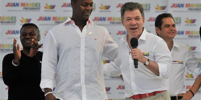 Colombia's President Juan Manuel Santos speaks next to retired baseball player Edgar Renteria during a campaign rally at the Tomas Arrieta baseball stadium in Barranquilla, Colombia, Sunday, March 16, 2014. Santos, who is running for re-election, said on a televised statement on Tuesday, March 18, that he suffered an accident of incontinence product of surgery he underwent a year and a half ago to remove prostate cancer, that according to his doctor the accident is normal in patients who have suffered such intervention and that his health is optimal. (AP Photo)
