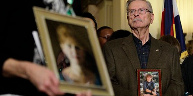 Bill Hoover carries a photo of his grandson AJ Boik, who was killed in the July, 2012 Aurora movie theatre massacre, during a news conference at which Colorado State legislators unveiled  gun control measures, at the State Capitol, in Denver, Tuesday Feb. 5, 2013. Among the proposed measures is a new bill that would hold manufacturers, sellers, and owners of assault weapons liable and responsible for damages caused by shootings with those weapons. (AP Photo/Brennan Linsley)
