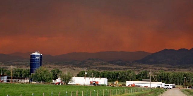 June 21, 2013: The smoke in the sky over a ranch near South Fork, Colo., glows red from a wildfire that is threatening the town. South Fork was evacuated Friday as the fire approaches from the west.