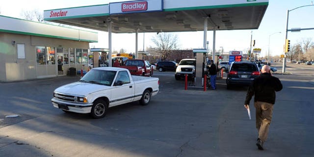 March 12, 2014: Longmont Det. Joel Post, right, talks on the phone outside the Bradley Sinclair gas station where a carjacking occurred in Longmont, Colo.