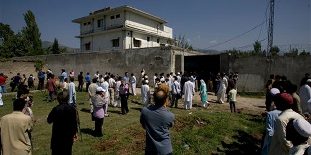 Local people and media gather outside the perimeter of the compound where Usama bin Laden was caught and killed in Abbottabad, Pakistan, May 3.