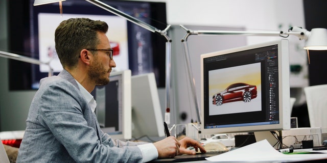 File photo: A man works in a showcase design studio at the fringes of a launch ceremony presenting the new Volkswagen Passat at the Volkswagen Design Center in Potsdam July 3, 2014. (REUTERS/Thomas Peter GERMANY - Tags: TRANSPORT BUSINESS)