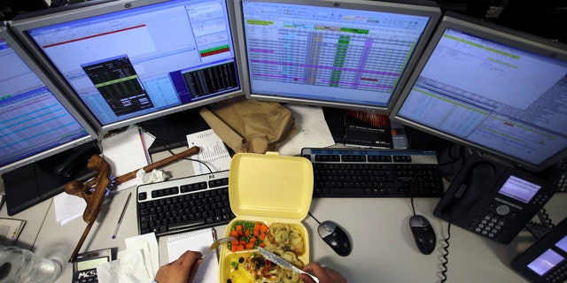 A dealer eats his lunch as he monitors his screens on the trading floor of IG Index in London May 6, 2010. (REUTERS/Kevin Coombs)