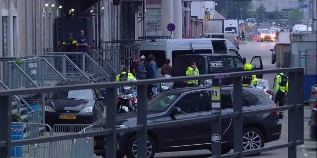 In this image taken from video people and security stand around a van in Rotterdam, Wednesday Aug. 23, 2017, after a concert by an American rock band was cancelled Wednesday night following a threat, the city's mayor said.