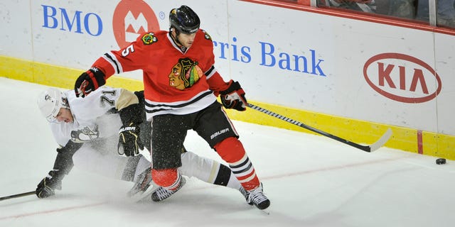 FILE - In this Sept. 30, 2011 file photo, Chicago Blackhawks defenseman Steve Montador, right, and Pittsburgh Penguins center Evgeni Malkin, of Russia, go for the puck during the first period of a preseason NHL hockey game, in Chicago. Montador is among a group of plaintiffs in a lawsuit brought against the NHL over concussion repercussions that has grown to well over 100 former players, who believe the league ignored a duty to warn them of the risks of head injuries. (AP Photo/Brian Kersey, File)