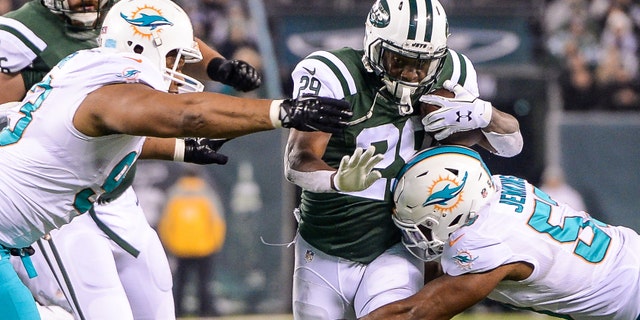 Dec 17, 2016; East Rutherford, NJ, USA; New York Jets running back Bilal Powell (29) is tackled by Miami Dolphins outside linebacker Jelani Jenkins (53) at MetLife Stadium. Mandatory Credit: Dennis Schneidler-USA TODAY Sports - RTX2VHTA