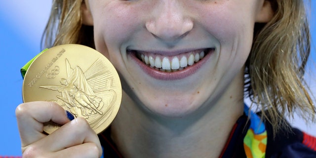 Aug. 12, 2016: United States' Katie Ledecky shows off her gold medal in the women's 800-meter freestyle medals ceremony during the swimming competitions at the 2016 Summer Olympics in Rio de Janeiro, Brazil.