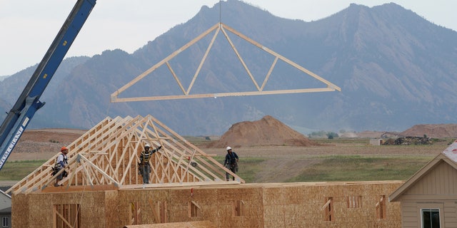 Workers install roof trusses onto a new house in Arvada, Colorado July 10, 2017. REUTERS/Rick Wilking - RTX3AX1O