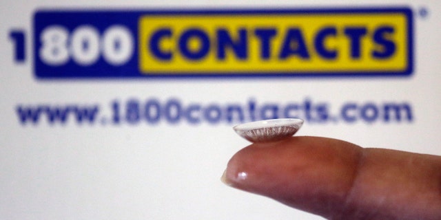 In this file photo, a contact lens is displayed in front of a 1-800-Contacts shipping box in Salt Lake City.