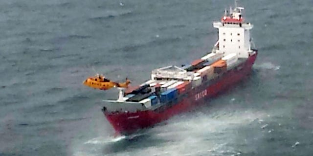 Oct. 17, 2014: A Canadian Coast Guard helicopter flies near a Russian container ship, carrying hundreds of tons of fuel drifting without power in rough seas off British Columbia's northern coast