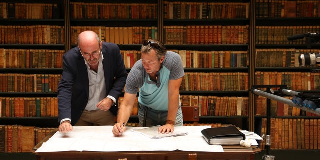 Darrell Miklos and Manuel Rodriguez go over ancient documents in a library in Jevez, Spain.