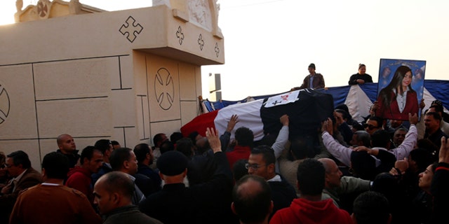 The body of one of the victims from Sunday’s bombing of Cairo’s main Coptic Cathedral is carried to be buried at the Mokattam Cemetery.