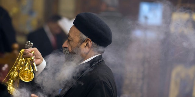 Coptic Orthodox priest, Pakhomios, spreads incense during Christmas Eve Mass at Virgin Mary church in Cairo, Egypt, late Saturday, Jan. 6, 2018.