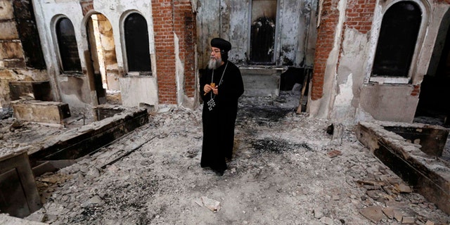 A Coptic Orthodox bishop surveys a damaged church in late August in Minya, Egypt. Concelebrating Mass with the leader of Egypts Coptic Catholics, Pope Francis prayed for the safety and religious liberty of Christians in the Middle East. (CNS photo/Louafi Larbi, Reuters) (Dec. 9, 2013) See POPE-COPTS Dec. 9, 2013.
