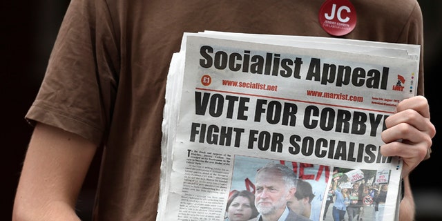 Aug 8, 2015: An activist holds a political paper as British Labor Party politician Jeremy Corbyn arrives for a community meeting in north London. (Reuters)