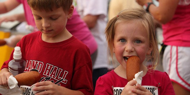 Children are shown enjoying a corn dog at the Tulsa State Fair in Oklahoma. 