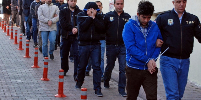 Police officers escort people, arrested because of suspected links to U.S.-based cleric Fethullah Gulen, in Kayseri, Turkey, Wednesday, April 26, 2017.