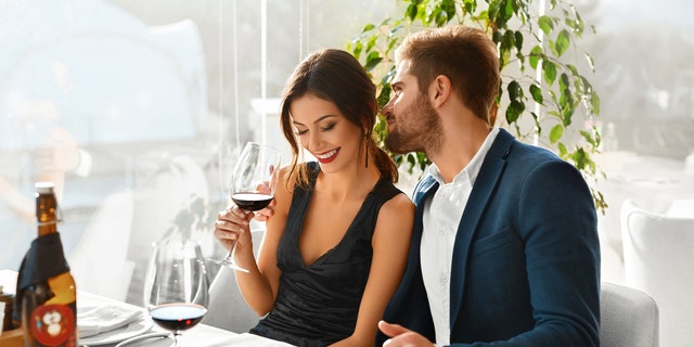 Couple In Love. Happy Romantic Smiling Elegant People Having Dinner, Drinking Wine, Celebrating Holiday, Anniversary Or Valentine's Day In Gourmet Restaurant. Romance, Relationships Concept.