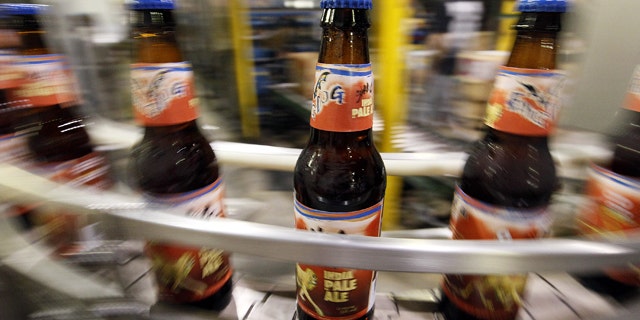 In this July 25, 2011 photo, beer bottles move along a conveyor belt after being filled at the Flying Dog Brewery in Frederick, Md. The company plans to end shipments to more than a dozen states beyond the east coast in order to burnish its image as a craft brewer and attract more consumers who are interested in buying local. (AP Photo/Patrick Semansky)