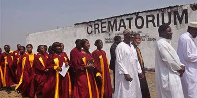 March 7, 2015: Traditional leaders, right, walk as a choir follows before the start of a ceremony for people who died due to the Ebola virus and who got cremated at a crematorium on the outskirts of Monrovia, Liberia.