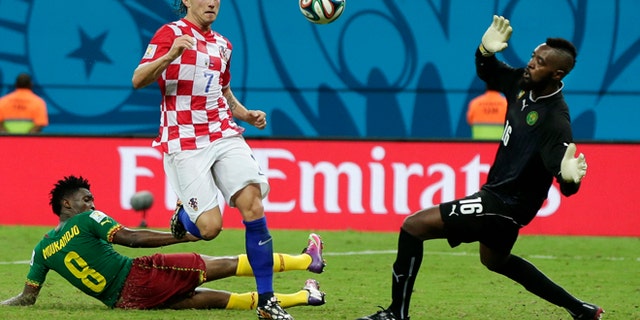 June 18, 2014: Croatia's Ivan Rakitic (7) kicks against Cameroon's goalkeeper Charles Itandje (16) during the group A World Cup soccer match between Cameroon and Croatia at the Arena da Amazonia in Manaus, Brazil.