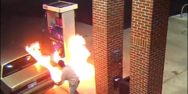 Image from surveillance video shows motorist starting gas station blaze trying to kill spider with lighter.