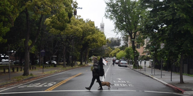 A homeless man walks with his dog in Berkeley, Calif.