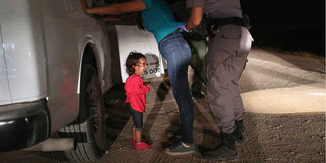 MCALLEN, TX - JUNE 12:  A two-year-old Honduran asylum seeker cries as her mother is searched and detained near the U.S.-Mexico border on June 12, 2018 in McAllen, Texas. The asylum seekers had rafted across the Rio Grande from Mexico and were detained by U.S. Border Patrol agents before being sent to a processing center for possible separation. Customs and Border Protection (CBP) is executing the Trump administration's zero tolerance policy towards undocumented immigrants. U.S. Attorney General Jeff Sessions also said that domestic and gang violence in immigrants' country of origin would no longer qualify them for political asylum status.  (Photo by John Moore/Getty Images)