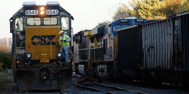 A CSX coal train, right, moves past an idling CSX engine at the switchyard in Brunswick, Md., Oct. 16, 2012.