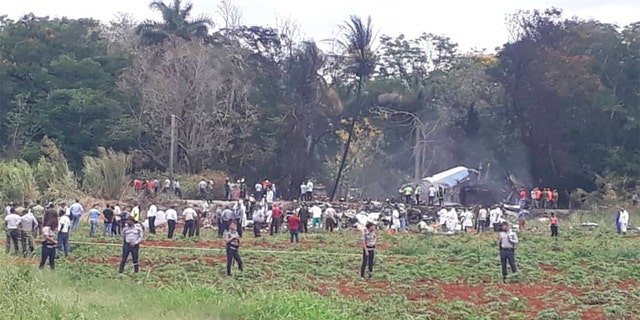 Rescue and search workers on the site where a Cuban airliner with 104 passengers on board plummeted into a yuca field just after takeoff from the international airport in Havana, Cuba on Friday.