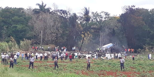 Rescue and search workers on the site where a Cuban airliner with 104 passengers on board plummeted into a yuca field just after takeoff from the international airport in Havana, Cuba on Friday.