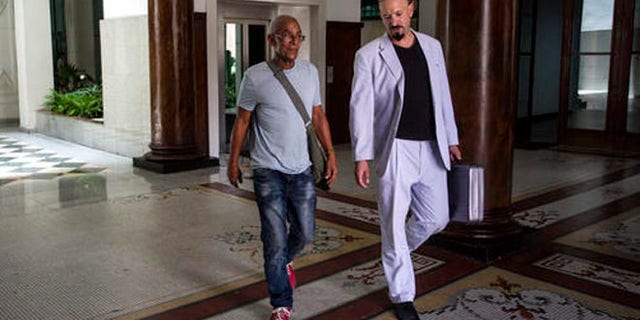 U.S. fugitive Charles Hill, left, walks with his lawyer Jason Flores Williams after an interview in Havana, Cuba, Friday, June 10, 2016. Hill, 66, who is sought in the 1971 killing of a New Mexico state policeman, told The Associated Press that Cuban contacts recently assured him he was at no risk of extradition. (AP Photo/Desmond Boylan)