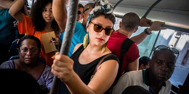 En esta foto del 12 de junio de 2016, la cubanoestadounidense Fontaine Capel, centro, viaja en autobús en La Habana, Cuba. Capel viajó a Cuba con CubaOne, un programa inspirado en el restablecimiento de las relaciones entre Estados Unidos y Cuba. (AP Foto/Ramon Espinosa)