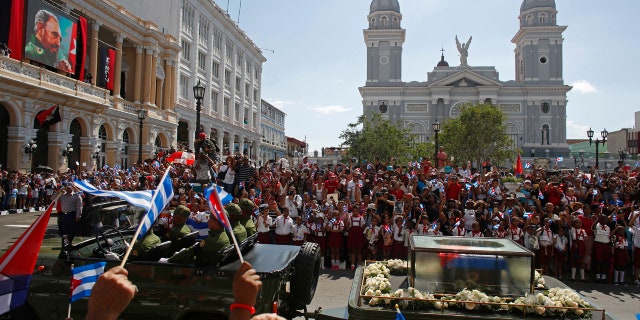 People chant "I am Fidel!" as the motorcade carrying the ashes of the late Cuban leader Fidel Castro leaves Cespedes park in Santiago, Cuba, Saturday, Dec. 3, 2016.