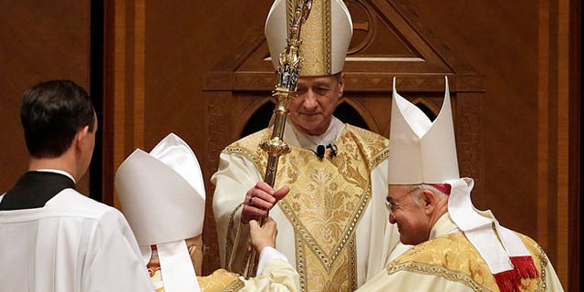 Nov. 18, 2014: The retiring Cardinal Francis George presents the crozier to the Archbishop Blase Cupich during his Installation Mass at Holy Name Cathedral in Chicago. (AP)