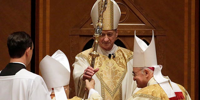 Nov. 18, 2014: The retiring Cardinal Francis George presents the crozier to the Archbishop Blase Cupich during his Installation Mass at Holy Name Cathedral in Chicago. (AP)