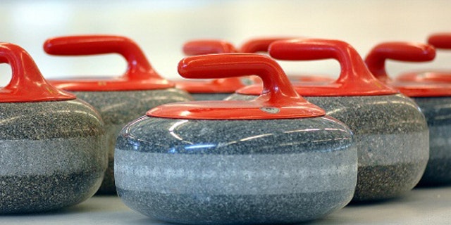 A set of curling stones rests on the ice. Each stone weighs about 41 pounds.