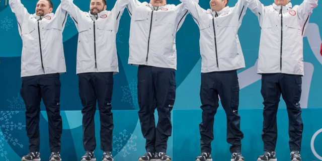 The U.S. Men's Curling team celebrates their gold medal on the podium in Pyeongchang, South Korea.