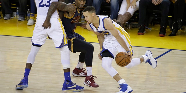 June 5, 2016: Golden State Warriors guard Stephen Curry (30) dribbles as forward Draymond Green (23) blocks Cleveland Cavaliers guard Iman Shumpert during the second half of Game 2 of basketball's NBA Finals in Oakland, Calif.