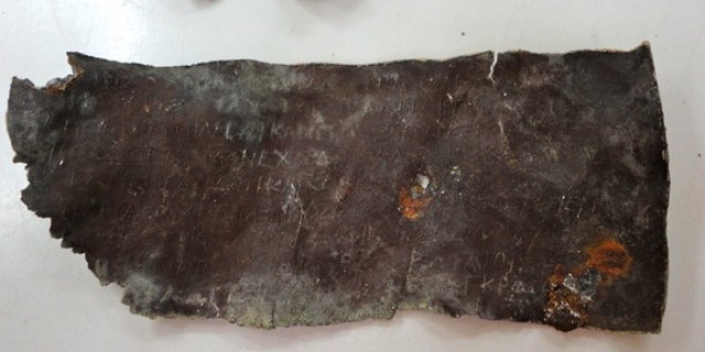 Here, the lead tablet engraved with a curse against husband-and-wife tavern keepers, Demetrios and Phanagora.