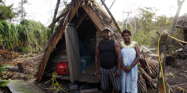 March 19, 2015: Kelson Hosea and wife Joyce Hosea stand next to the hut Kelson built to withstand Cyclone Pam.