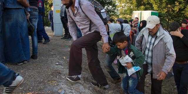 Aug. 31, 2015: Refugees who crossed the border from Serbia climb on a road to board a bus to transfer them to a refugee camp, in Asotthalom, Hungary. Migrants fearful of death at sea in overcrowded and flimsy boats have increasingly turned to using a land route to Europe through the Western Balkans.