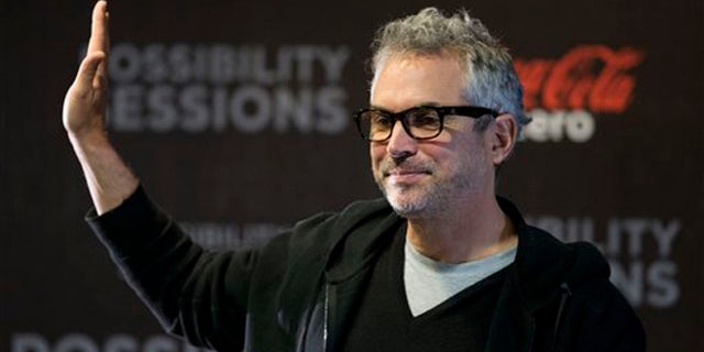 Alfonso Cuaron waves at the close of a press conference in Mexico City, Wednesday, April 30, 2014.